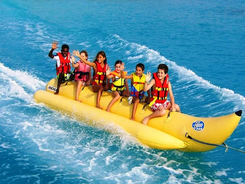 Guests riding a banana boat across the turquoise Red Sea