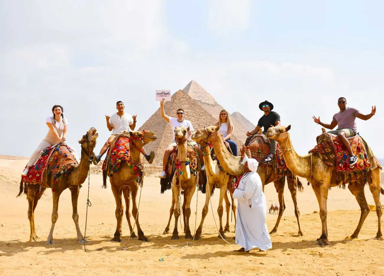 Guests on a camel caravan before the Pyramids of Giza