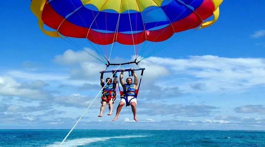 A pair parasailing above the Red Sea under a colourful canopy