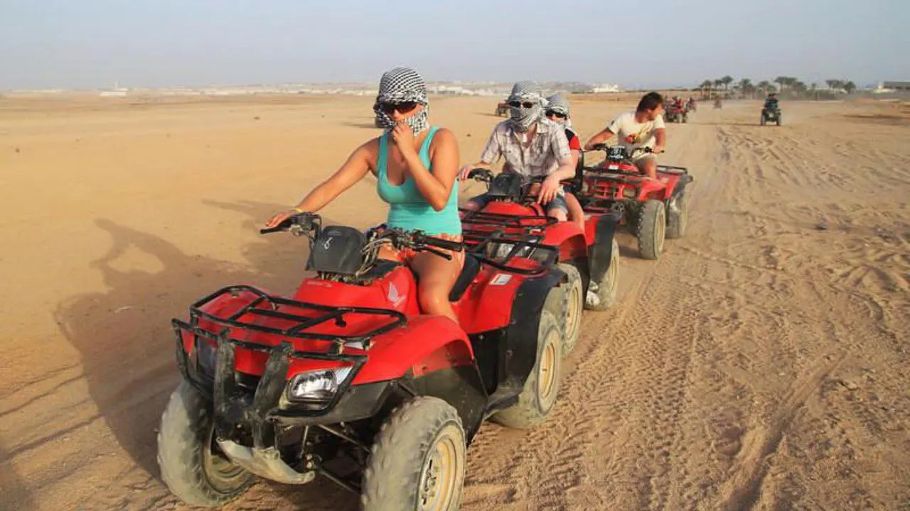 Guests quad biking across desert dunes near the Giza pyramids