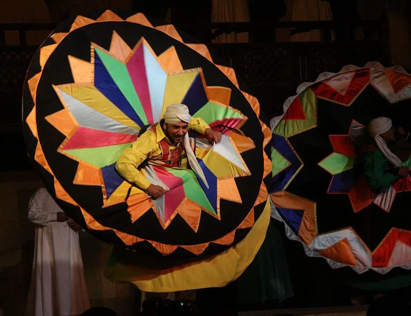 A Sufi tanoura performer spinning in a brightly coloured skirt