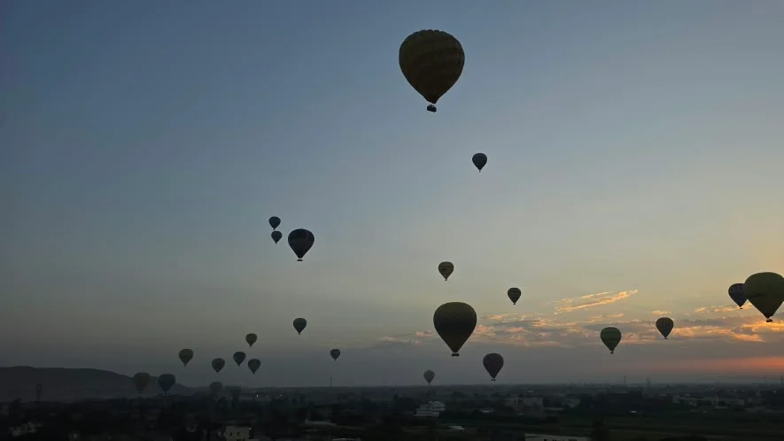 Mongolfiere che salgono nella prima luce sulla valle del Nilo a Luxor
