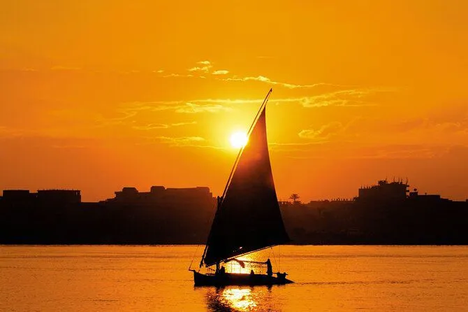 A felucca silhouetted on the Nile as the sun sets over the water