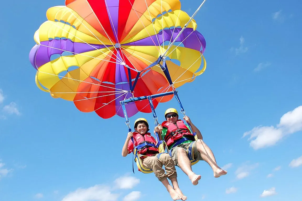 Guests parasailing high above the Red Sea under a bright canopy