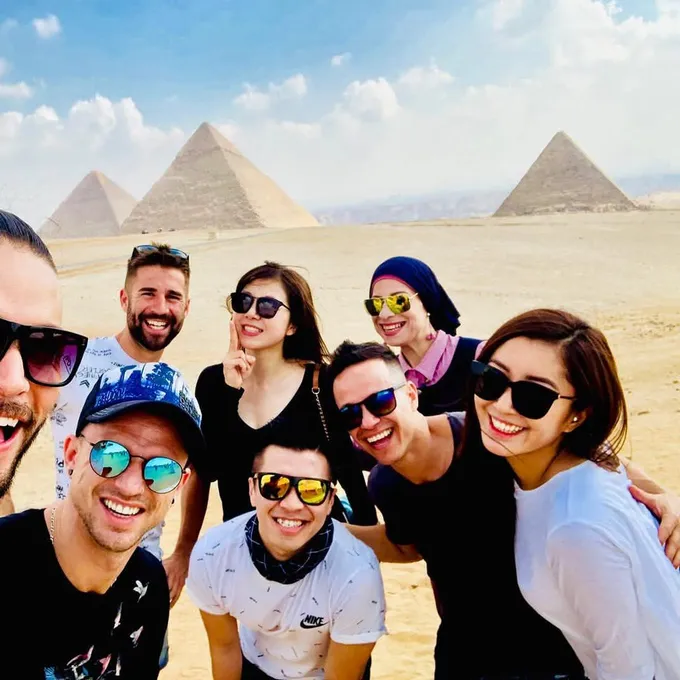 Kemet guests taking a laughing group selfie at the Pyramids of Giza