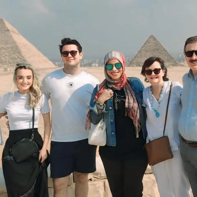 Guests smiling before the Great Sphinx and the pyramids at Giza