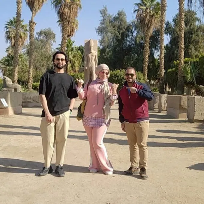 Guests among the palms beside an ancient obelisk