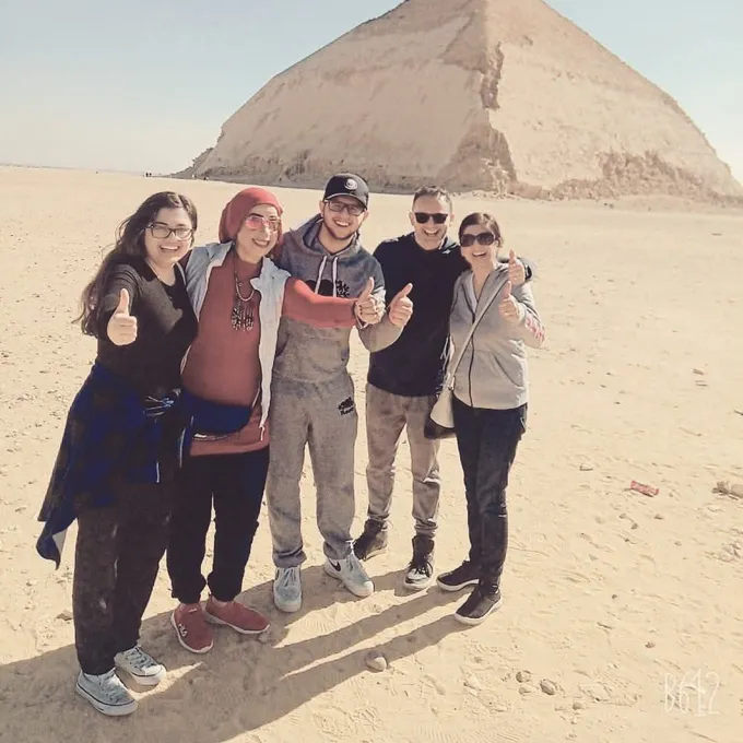 A cheerful group of guests giving a thumbs-up at Giza
