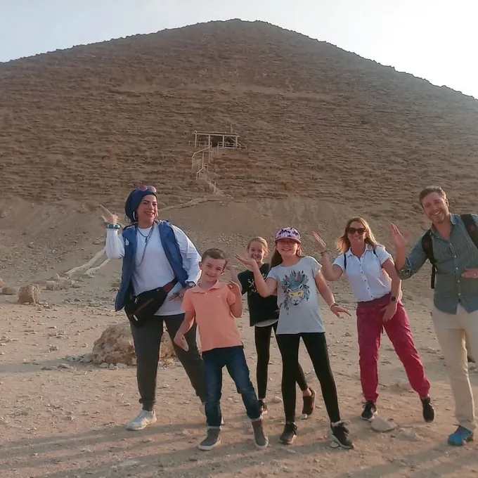 A family cheering at the base of the Red Pyramid of Dahshur
