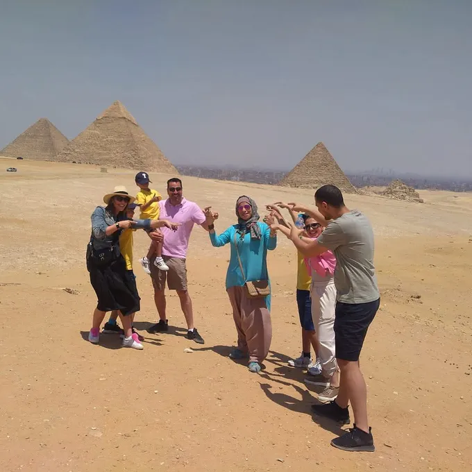 Guests posing playfully before the Pyramids of Giza