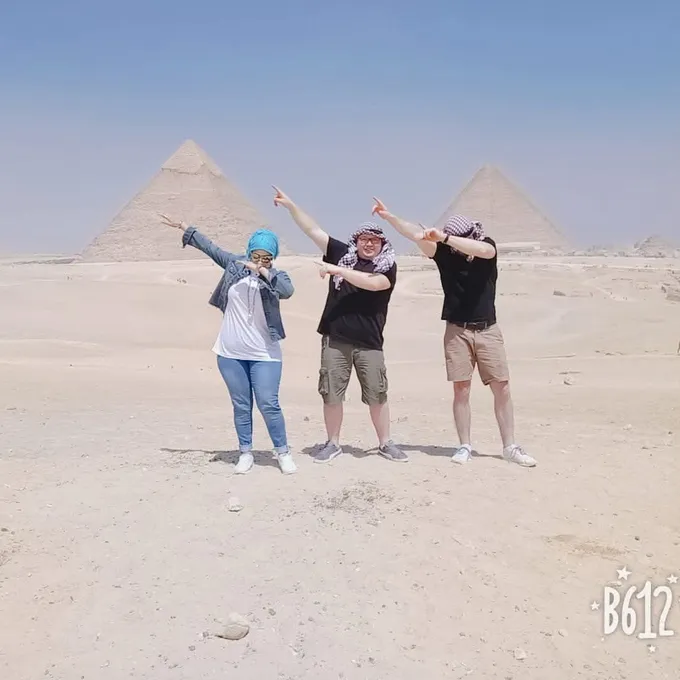 Guests celebrating with hands raised at the Giza pyramids