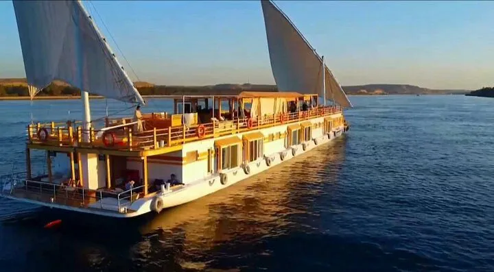 A Nile cruise ship reflected in the river at golden hour
