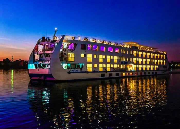 A Nile cruise vessel lit up on the water at night