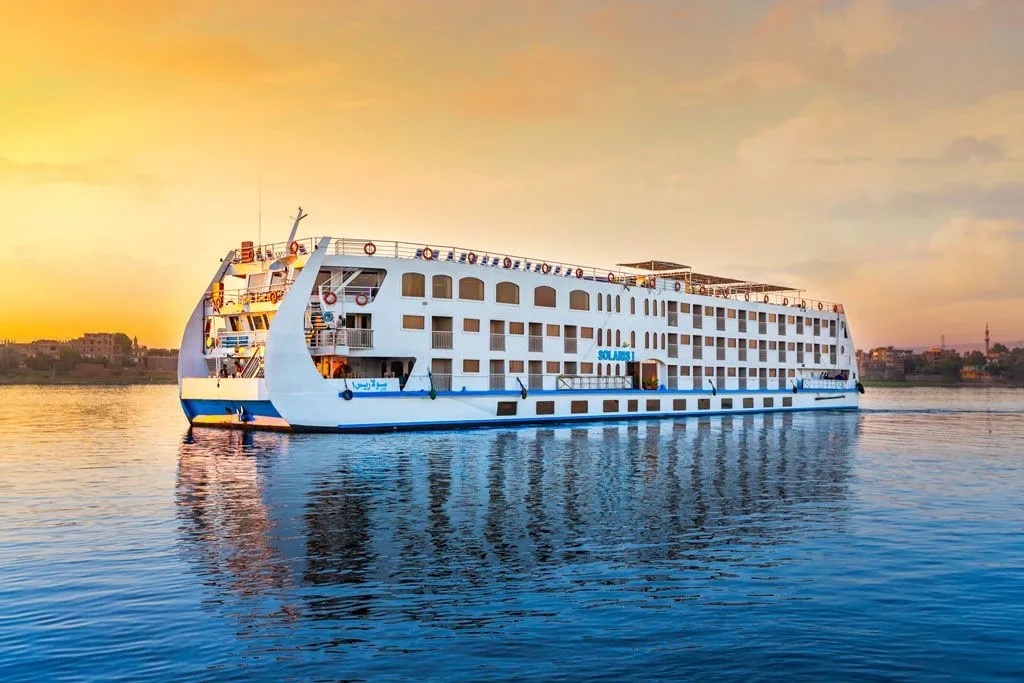 A Nile cruise ship gliding the river between Aswan and Luxor at sunset
