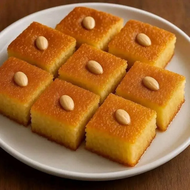 Potongan basbousa, masing-masing dengan sebutir almond