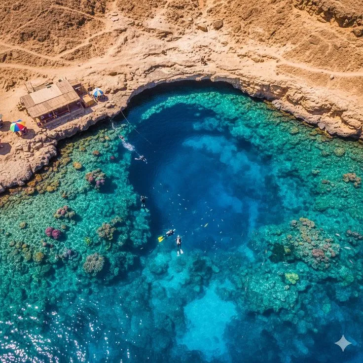 Snorkellers over the deep blue circle of a Red Sea reef hole