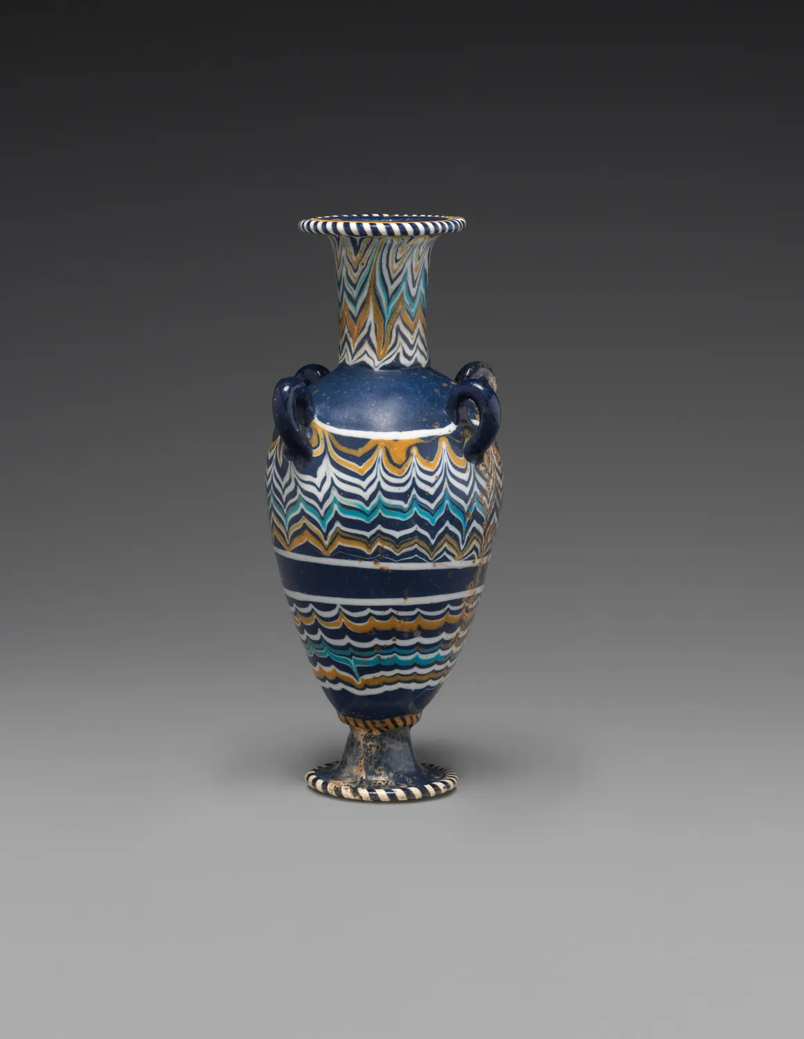 An ancient Egyptian perfume bottle of blue glass shaped like an amphora, about 1386–1330 BC