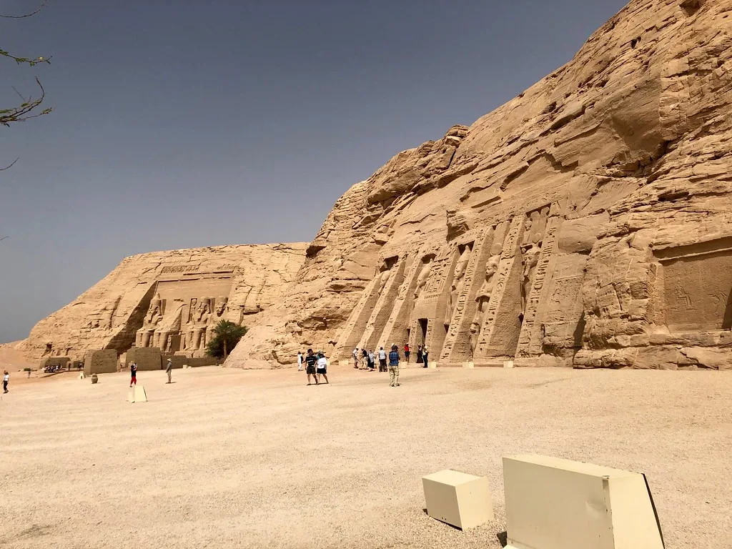 The two rock-cut temples of Abu Simbel: the Great Temple of Ramesses II in the distance and the Temple of Nefertari in front, with visitors on the forecourt
