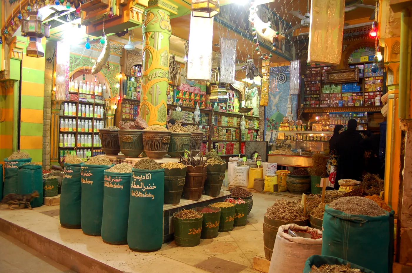 A spice and attar shop in Khan el-Khalili, sacks of herbs and spices before shelves of jars