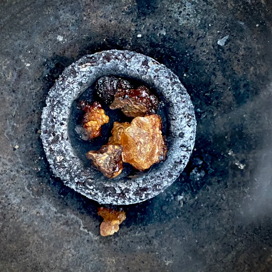 Pieces of myrrh smouldering on a charcoal ring